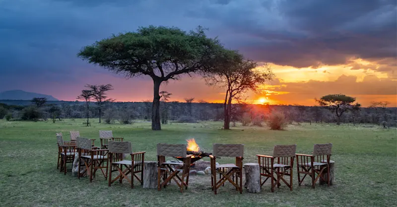 Sunset and campfire at Nat Hab's Mara East Camp, Private Mara Conservancy, Kenya.