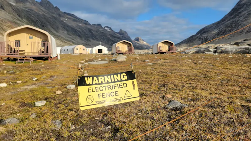Heeding caution near an electric fence at Base Camp Greenland.