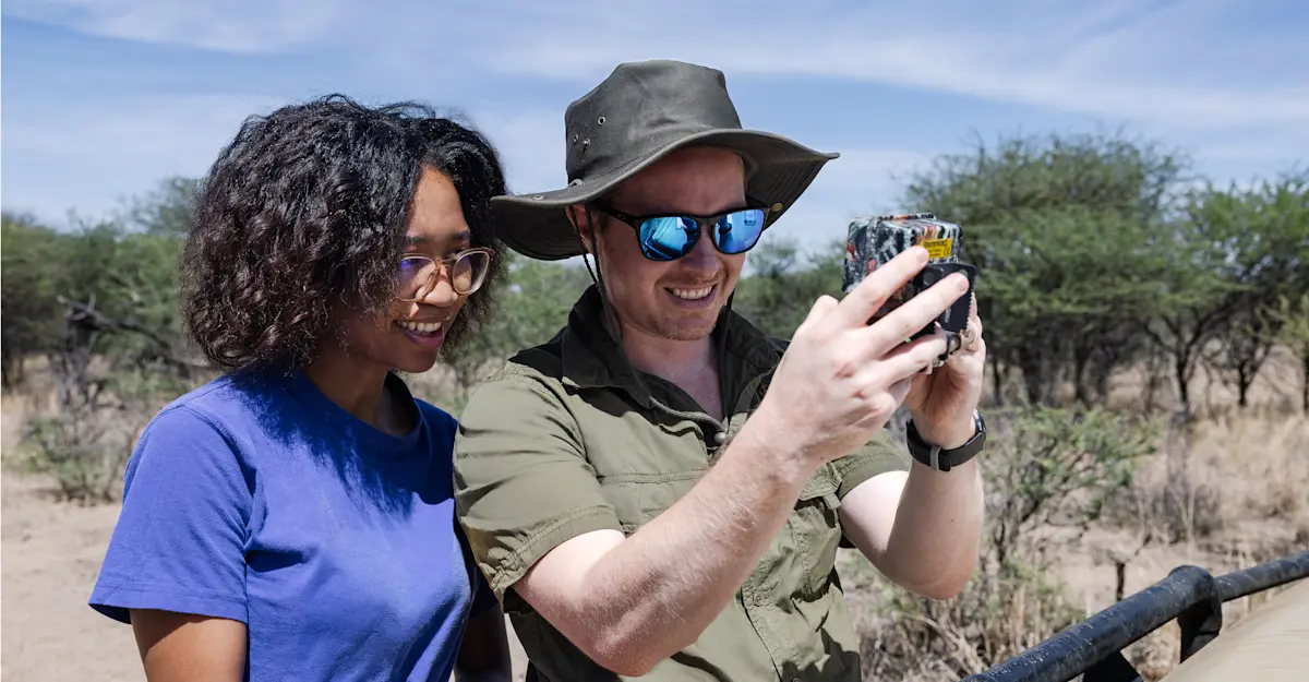 Earthwatch Expeditions scientist and participant viewing a camera trap, Namibia.