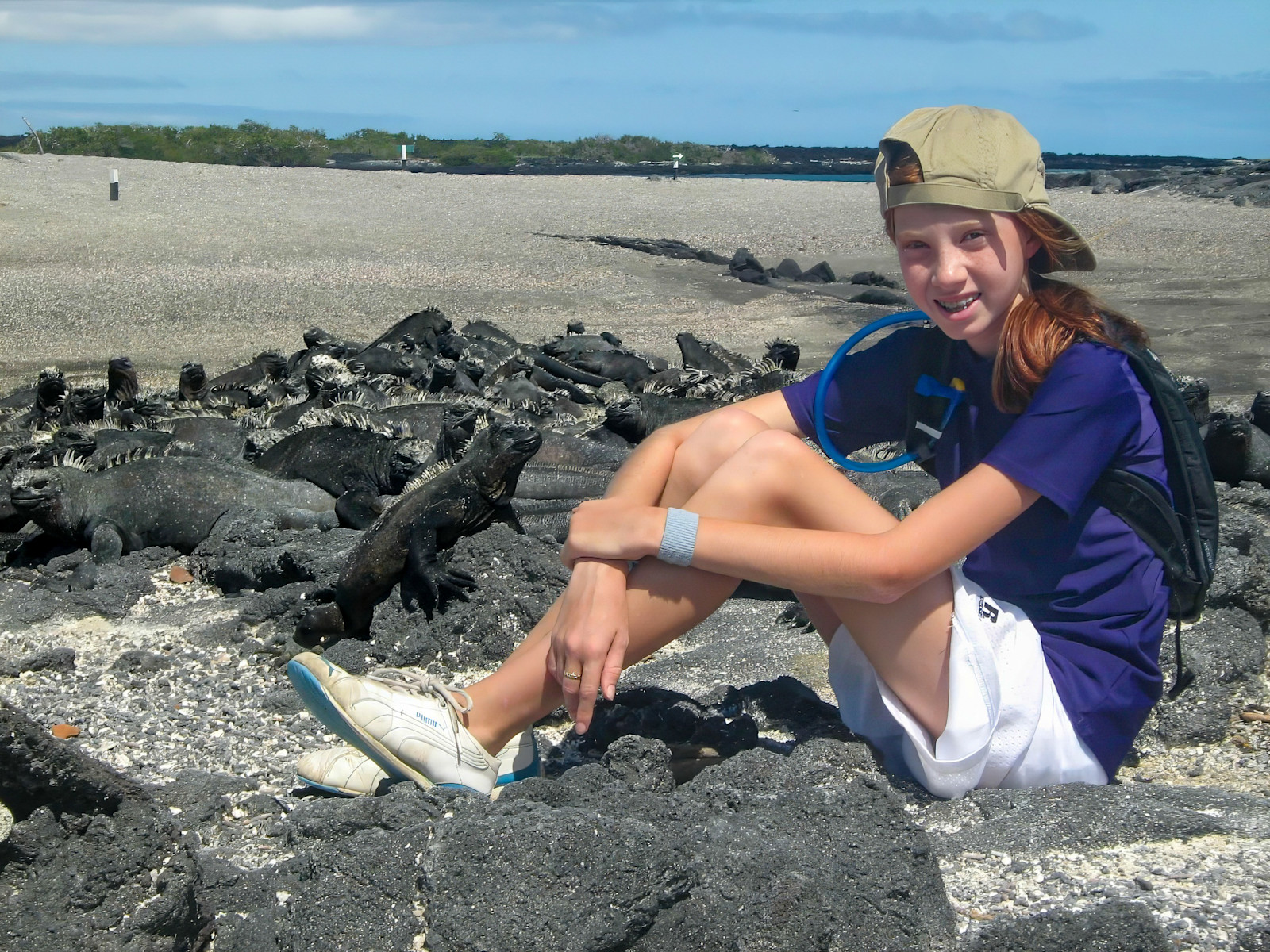 Middle-school-aged Meg chilling with Marine Iguanas in the Galapagos Islands.