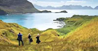 Travelers hiking up hillside, South Georgia Island.