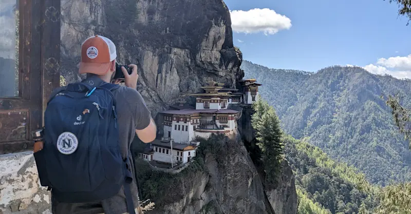 Nat Hab guest photographing Tiger's Nest, Taktsang Monastery, Bhutan.