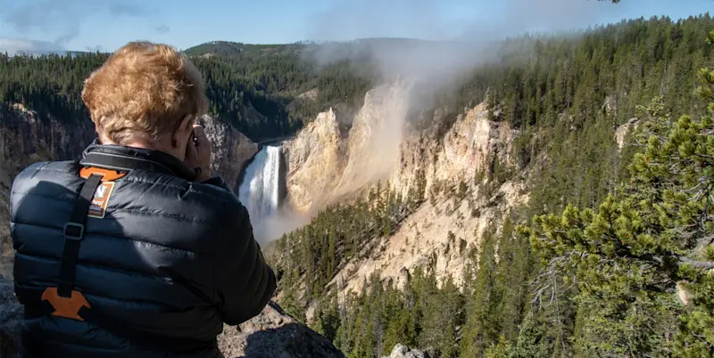 Nat Hab guest photographing Upper Falls, Yellowstone National Park, Wyoming.
