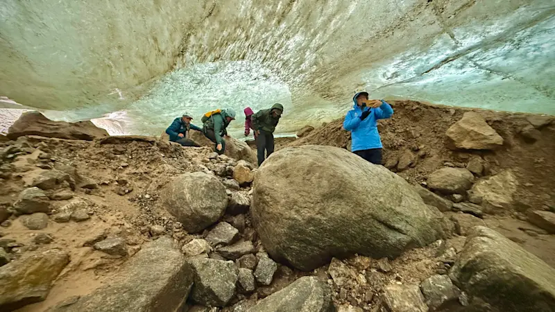 In Apusiak Glacier’s ice cave, ancient 100,000-year-old ice drips all around us, Greenland.