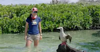 Nat Hab Expedition Leader and red-footed booby, San Cristobal Island, Ecuador.