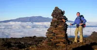 Hiking across volcanic landscapes with Mauna Kea on the horizon in Hawaii.
