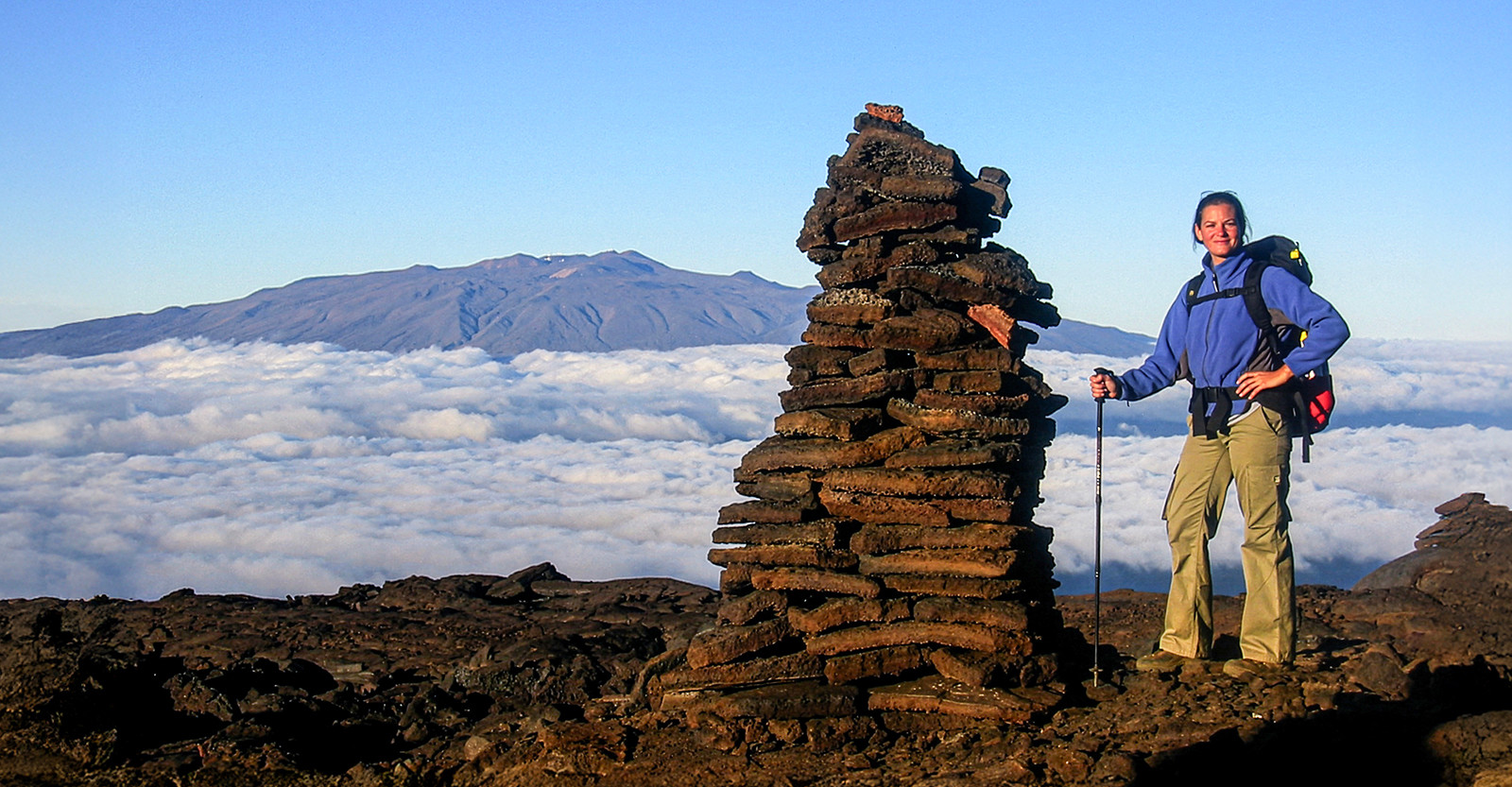 Hiking across volcanic landscapes with Mauna Kea on the horizon in Hawaii.