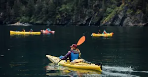 Guests kayaking Resurrection Bay, private Fox Island, Kenai Peninsula, Alaska.
