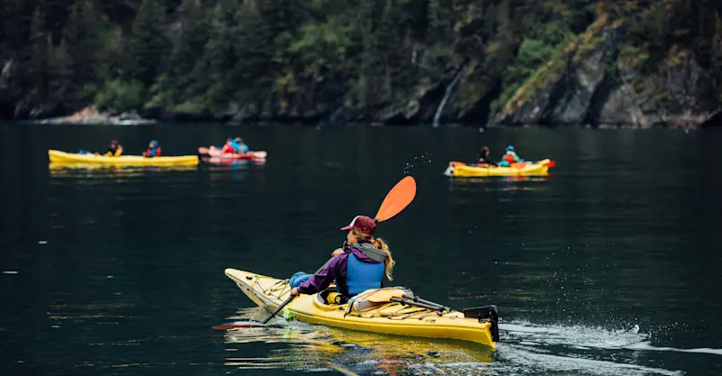 Guests kayaking Resurrection Bay, private Fox Island, Kenai Peninsula, Alaska.
