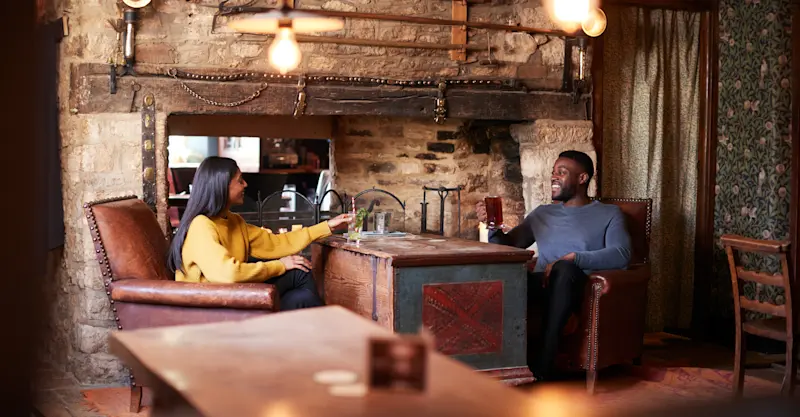 Travelers at traditional English pub, Cotswolds, England.