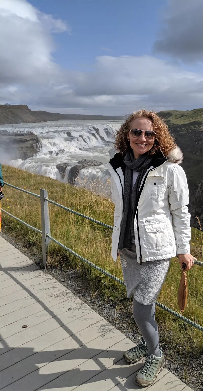 Standing near nature’s powerful waterfalls in Iceland.