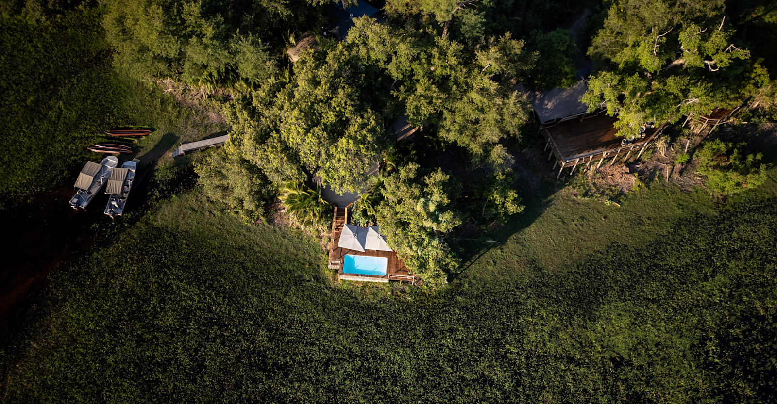 Aerial view of boating dock and pool at Nat Hab's Pelo Camp