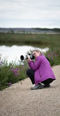 Nat Hab guest photographing wildflowers, Churchill, Manitoba.