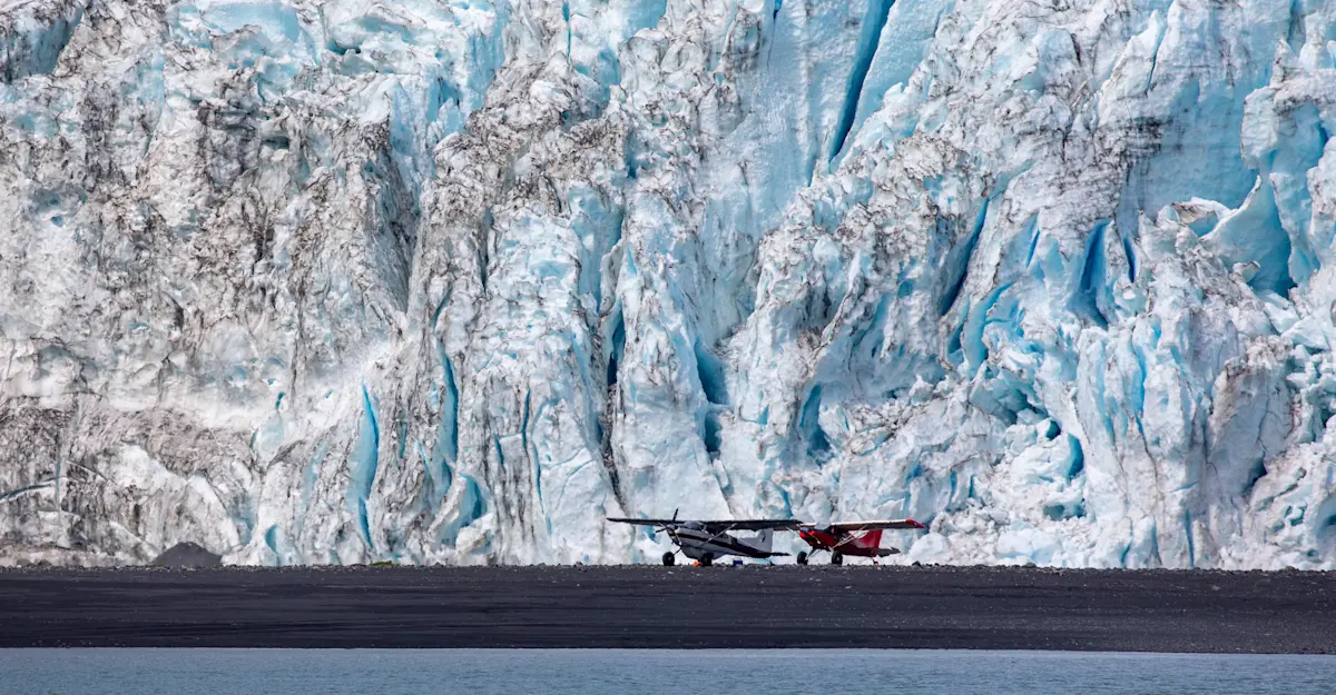 Gravel plans sit in front of a towering glacier in Kenai Fjords National Park, Alaska.