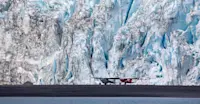Gravel plans sit in front of a towering glacier in Kenai Fjords National Park, Alaska.