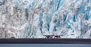 Gravel plans sit in front of a towering glacier in Kenai Fjords National Park, Alaska.