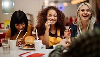 Three women eating fast food at a diner.
