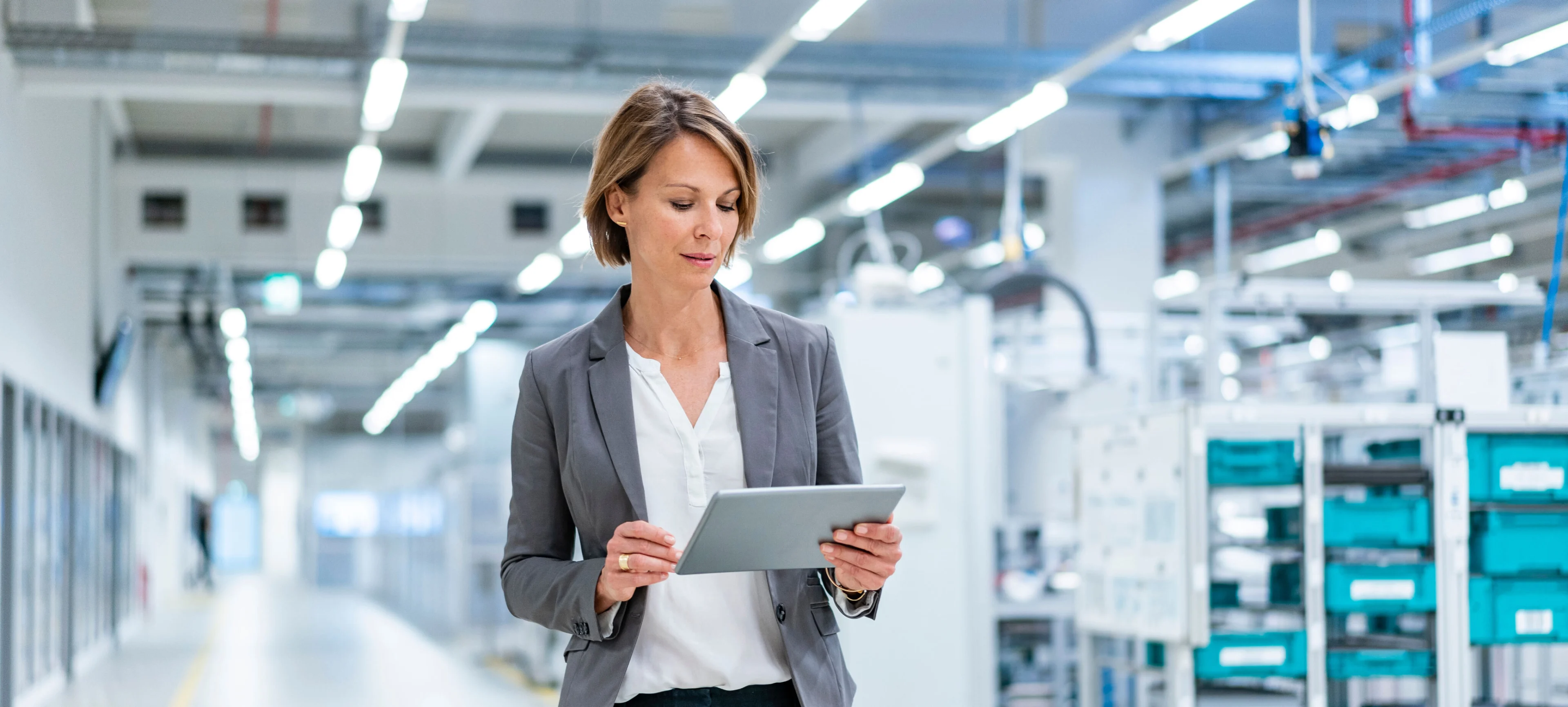 A person holding an electronic tablet in a manufacturing facility