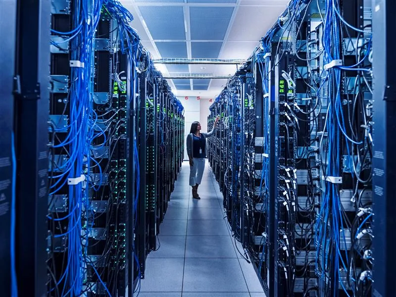 A person in a datacenter inspecting a server