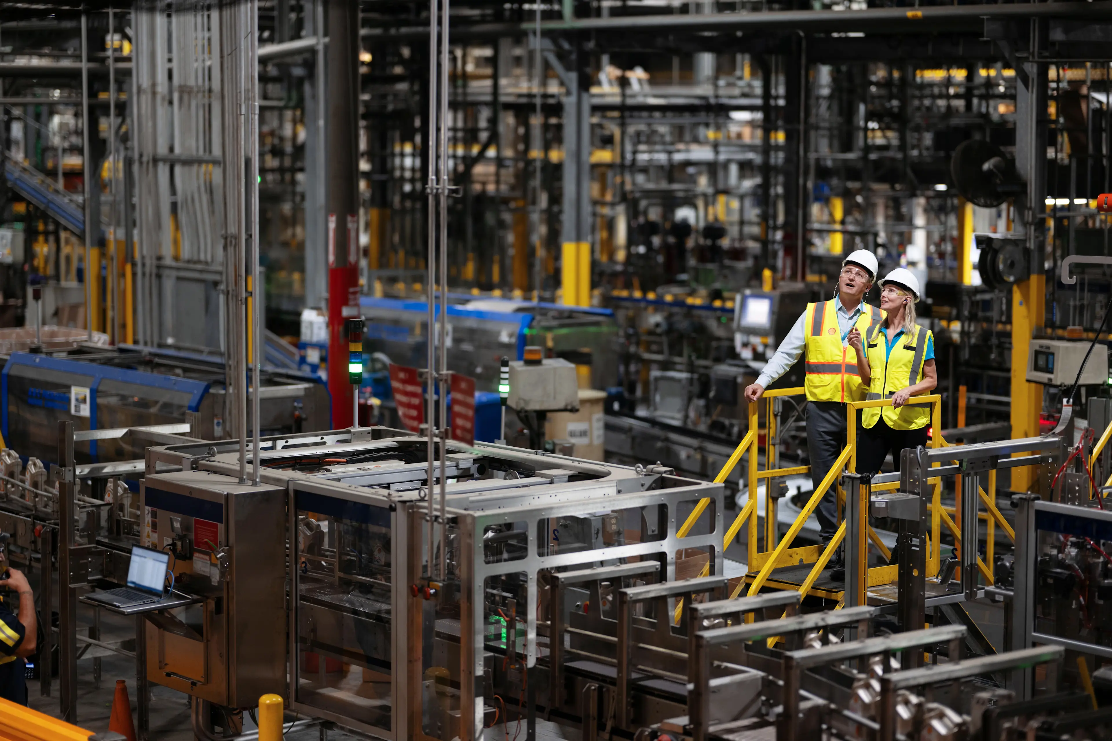 Two Shell workers in discussion at a manufacturing plant. 