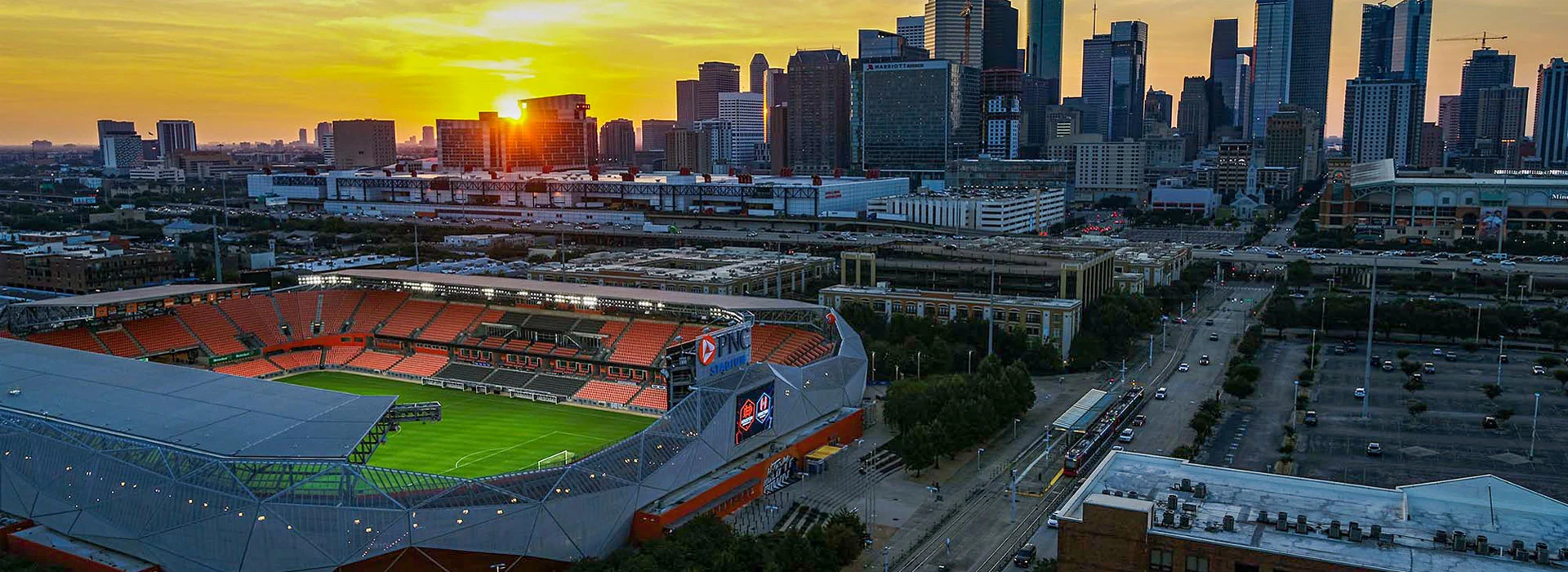 A photo of Shell Energy Stadium with the Houston skyline in the background
