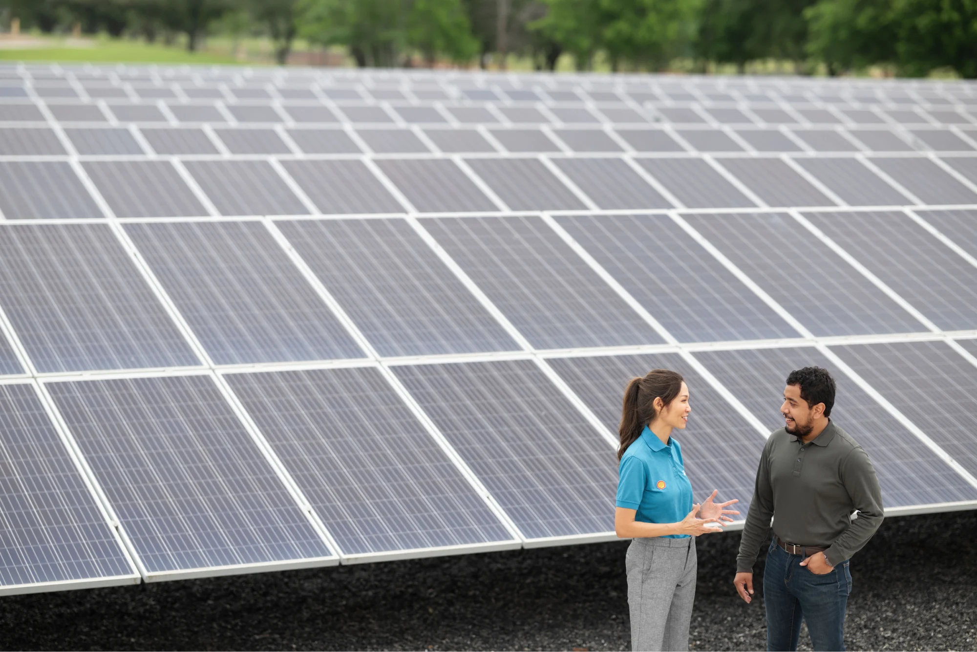 A Shell Energy representative and man having a conversation in front of a micro solar grid.