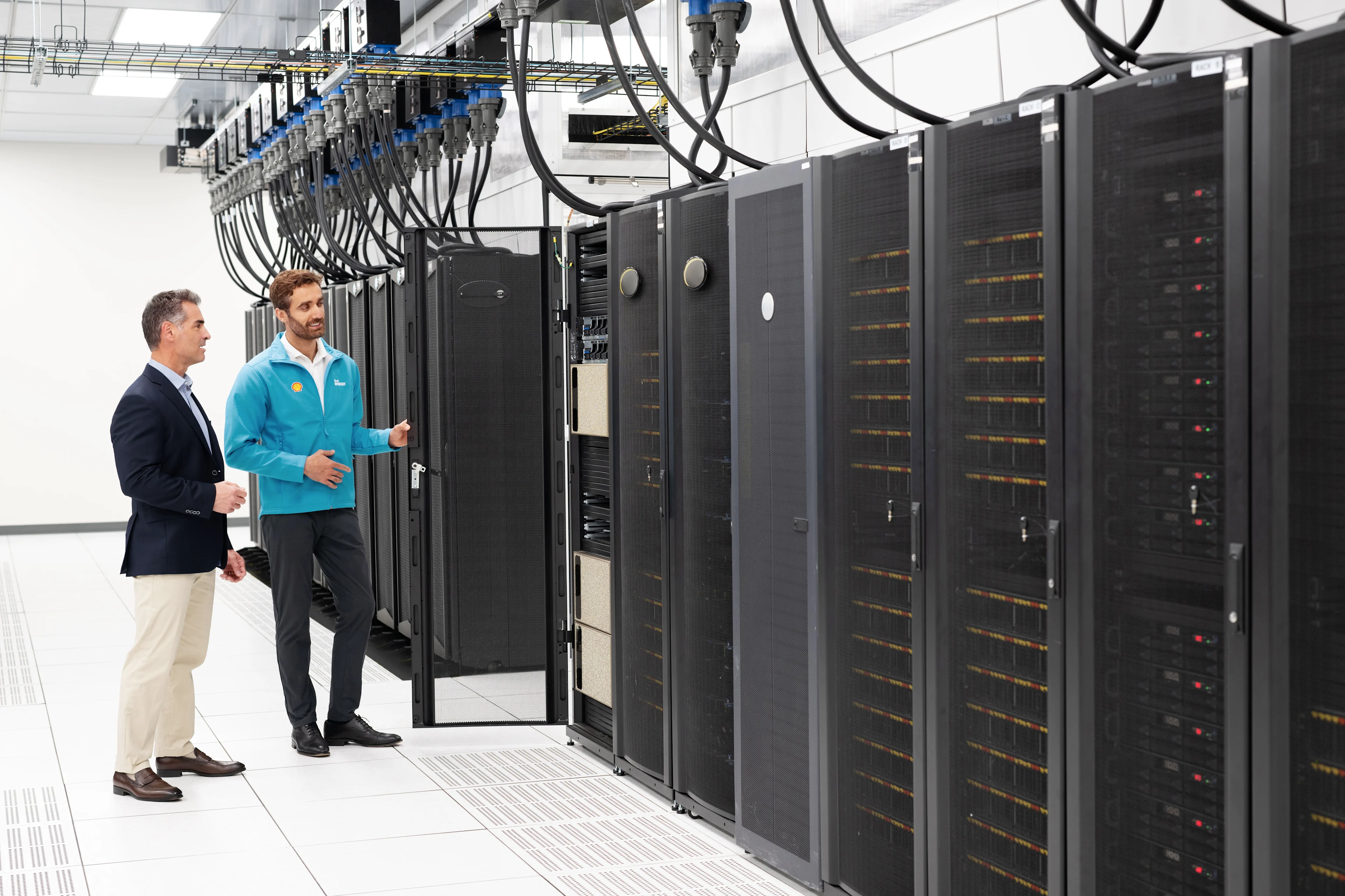 A man and a Shell Energy representative looking a data rack in a technology center.