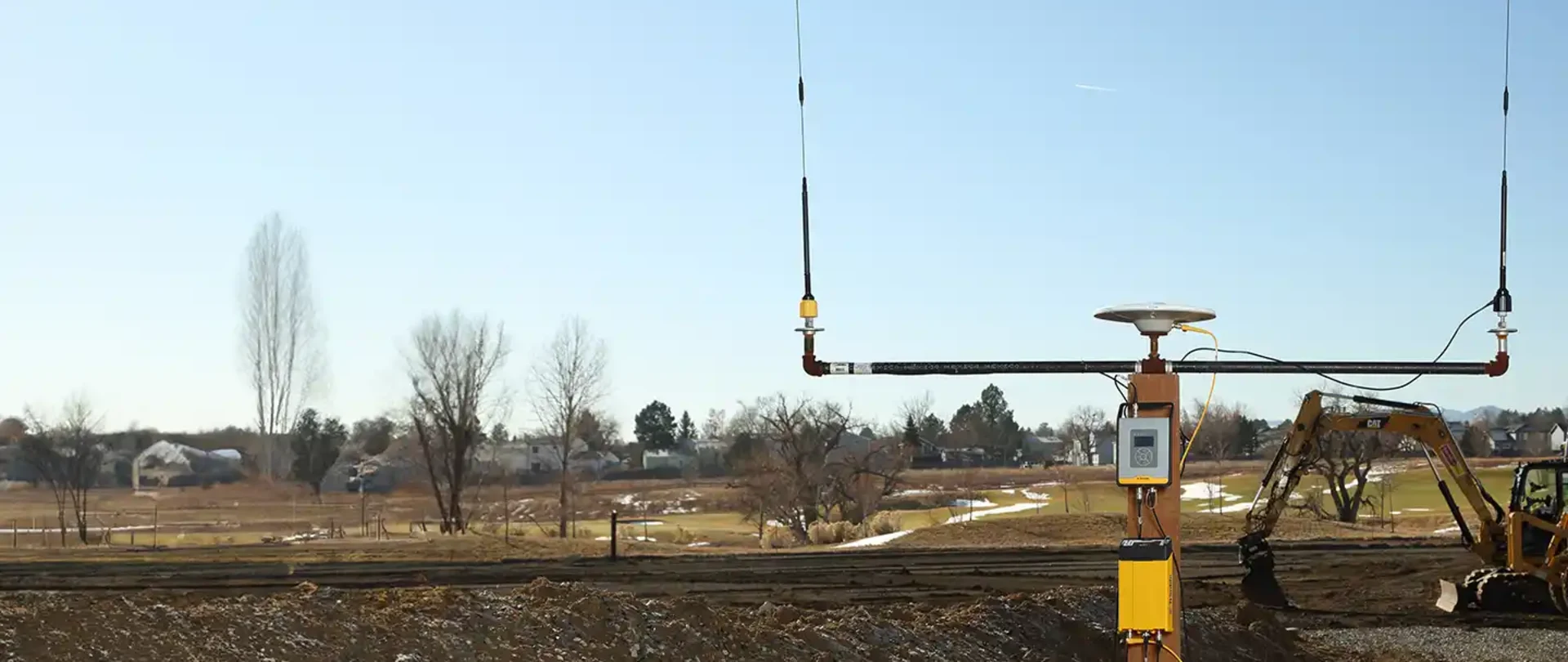 Trimble TDL450B Radio and R750 GNSS Modular receiver with construction site in the background