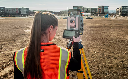 Surveyor using a T70 tablet mounted on a Trimble S-Series total station.