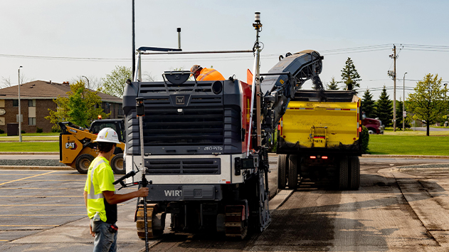 Worker uses Trimble Siteworks to monitor a Wirtgen milling machine with Trimble Roadworks on a roading project
