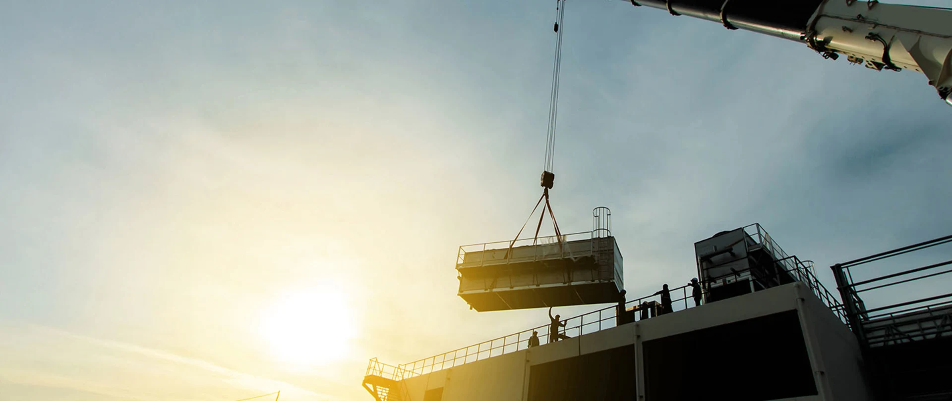 A crane lifting a large mechanical unit onto a roof