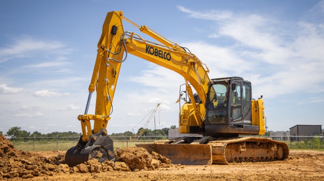Excavator digging a trench in a field