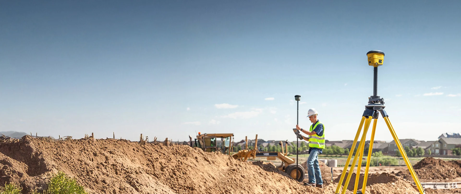 Trimble R780 smart antenna as a base station on a job site. A contractor uses the R580 antenna and TSC7 controller in the background