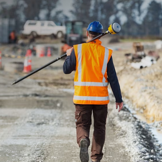 Géomètre de chantier transportant le système GNSS Trimble R780 sur le chantier