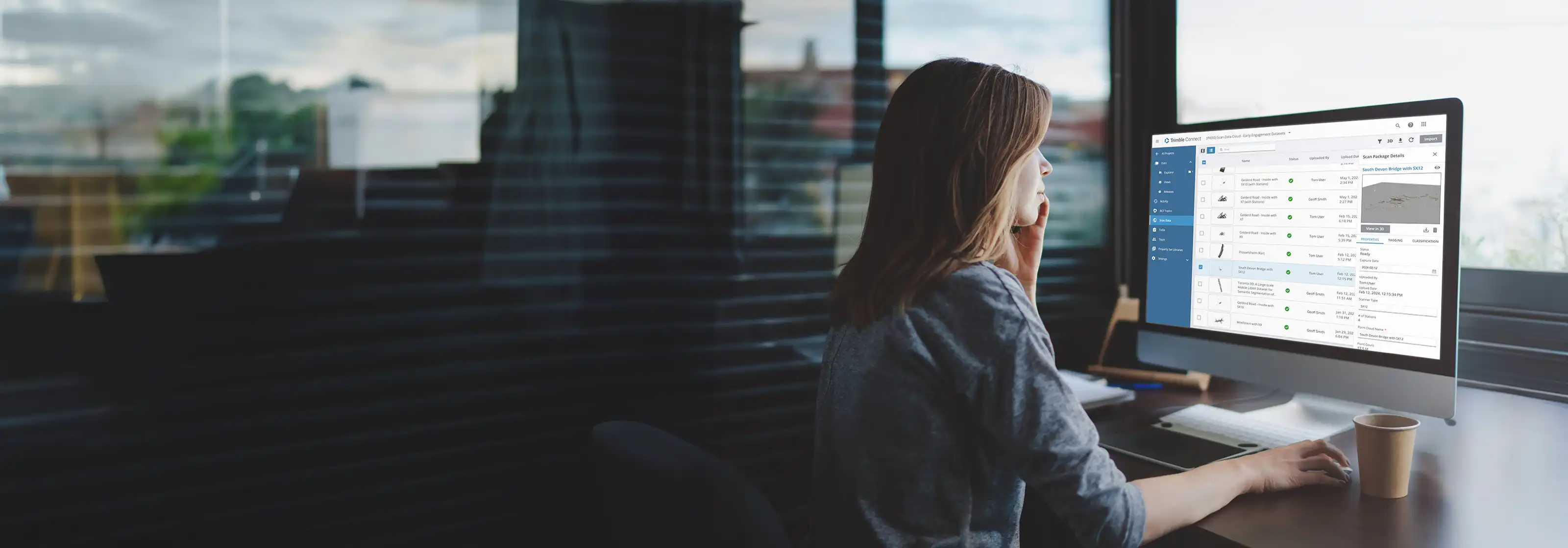 Woman at desk with Reality Capture cloud software on computer screen
