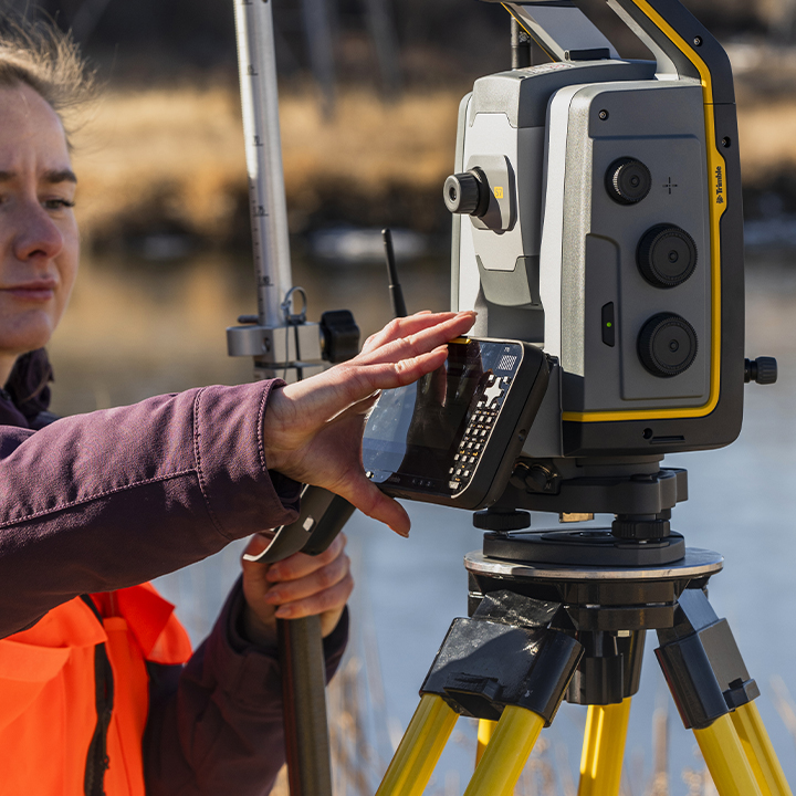测绘人员正在从 Trimble S 系列全站仪支架上拆下 Trimble T70 平板电脑