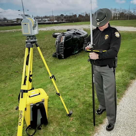 一名执法警员在交通事故现场附近操作 Trimble SX12 全站扫描一体机进行测绘作业