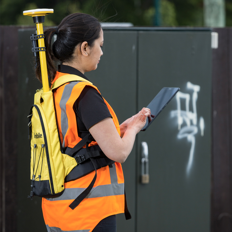 Géomètre en gilet haute visibilité utilisant Trimble Catalyst avec le récepteur DA2