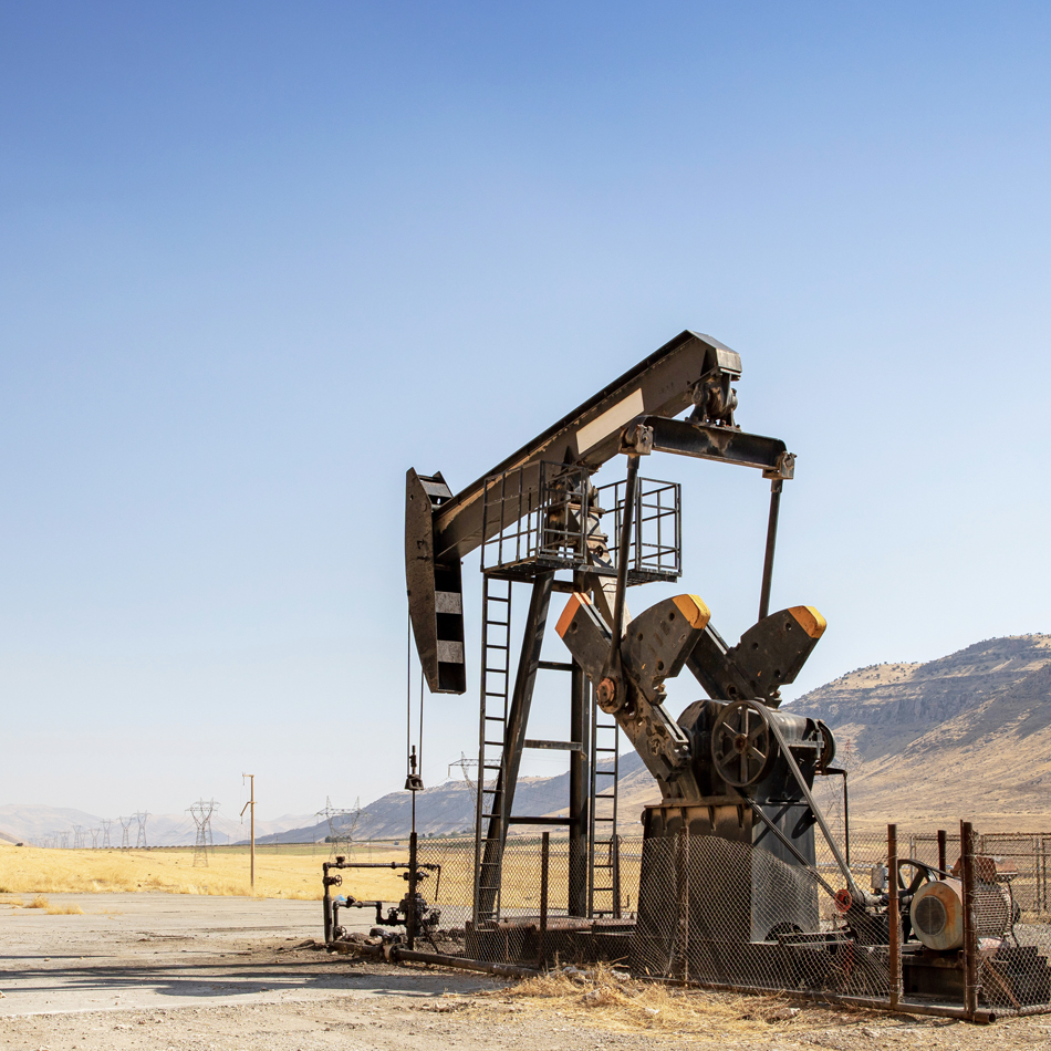 Eine einzelne Ölpumpe ist in der Mitte eines kargen Feldes positioniert.
