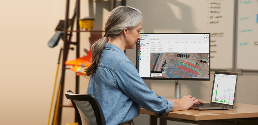 Worker in a construction office using WorksOS software for real-time jobsite visibility
