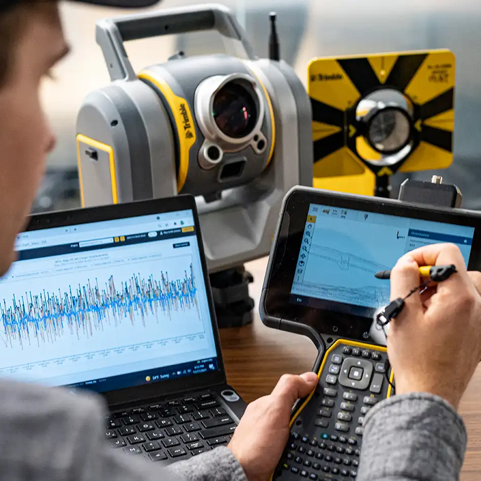 Eine Person nutzt mehrere Geodatenlösungen von Trimble