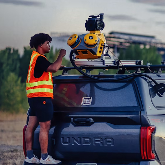 Worker in high-visibility vest setting up a Trimble MX60 mobile mapping system on the back of a truck