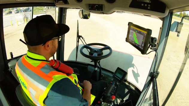 Worker inside a compactor cab using horizontal steering control