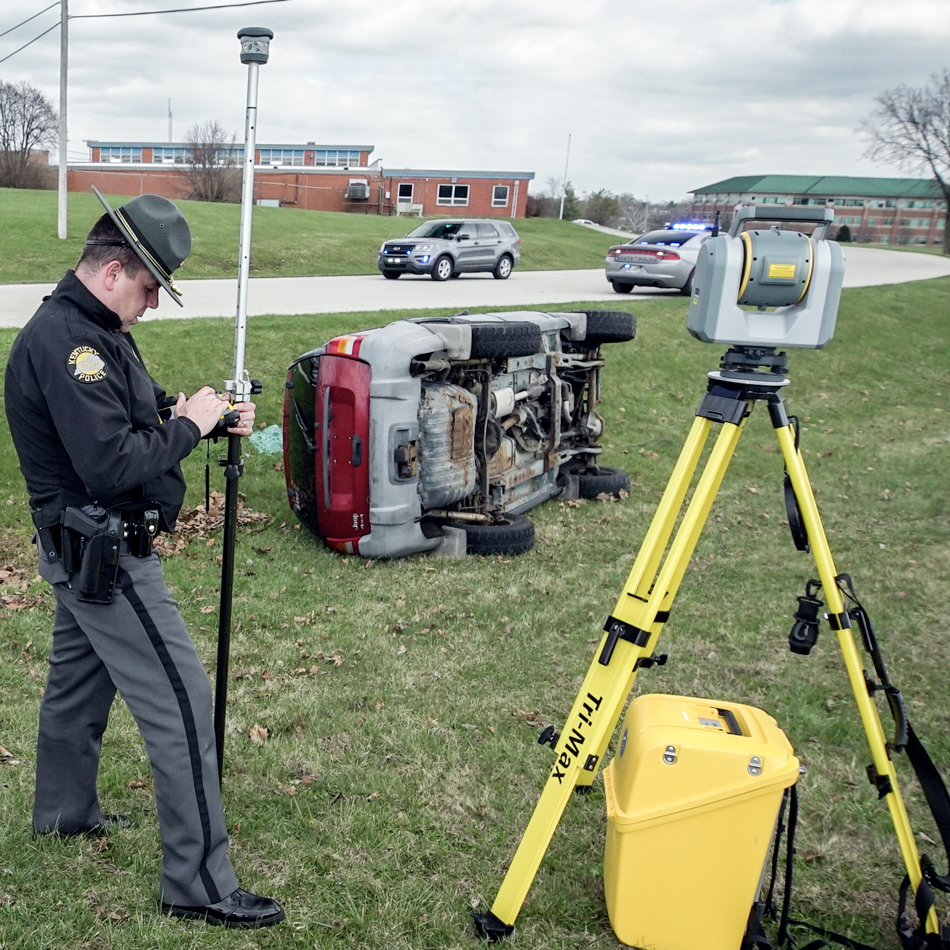 Law enforcement officer using Trimble SX10 total station and scanner for rollover analysis