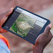 Construction worker on site using a tablet with Trimble Site Management software for field to office connectivity