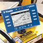 Close-up of a cab-mounted Trimble GS820 multi-sensor display in a crane showing critical information