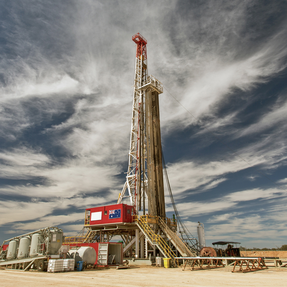 Eine Bohranlage steht prominent in einer weiten Wüstenlandschaft.