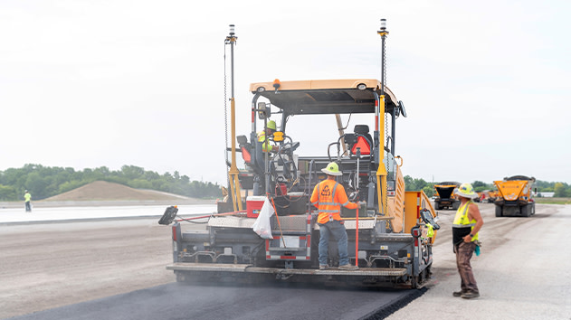 Paving crew using a paver with Trimble Roadworks to lay new asphalt surface