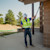 A surveyor in a hard hat and safety vest holds the ST30 smart target upside down against the underside of a building overhang whilst looking at his survey controller.