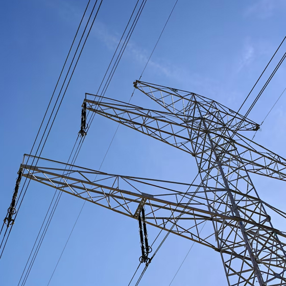 矗立在湛蓝晴空下的高压电力线塔
